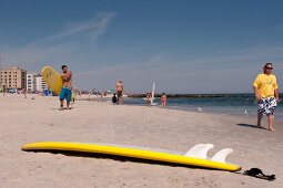 Man holding surfboard at Long Beach in New York, USA