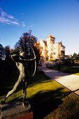 Statue holding bow and arrow near stone castle, Salzburg, Austria