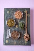Various herbal medicines in bowl and on wooden spoon, overhead view