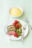 Lamb with a herb crust, courgette and tomatoes