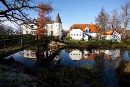 Ostseeküste: Blick auf Herrenhaus Gelting, Fassade weiss, Wasser