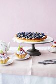 A blueberry tart with mascarpone and mini berry tartlets