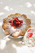 Waffles topped with slices of fruits on plate