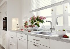 Flowers and sink on white kitchen working area