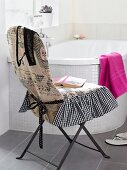 Bathroom chair with cover in front of bathtub in bathroom