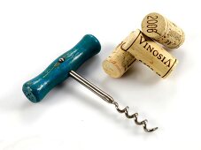 Three corks with cork screw on white background