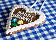Heart shaped lebkuchen cake with icing on blue and white checked table cloth