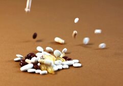 Close-up of colourful tablet and capsules falling on ground