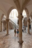 Tourists walking in portico of Rector's Palace, Dubrovnik, Croatia