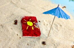 Towel and blue umbrella in the sand