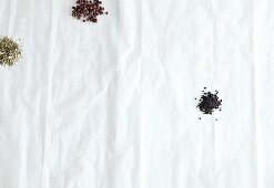 Various herbs and spices on white paper, overhead view