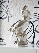 Kakadu figure against leaves patterned wallpaper