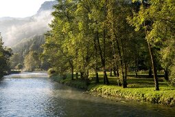 View of Loue river with fog near the village of Lods, Franche-Comte, France