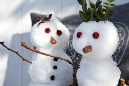Close-up of snow man and snow woman