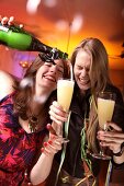 Two happy woman celebrating New Year with champagne