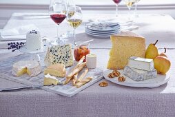 Käseplatten auf Tisch, verschiedene Käsesorten, Rotwein, Weißwein