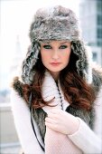 Portrait of red haired woman with grey eyes wearing fur hat with ear flaps