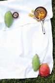 Ingredients for a mango dessert on a cloth on the grass
