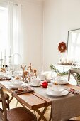 Table decoration with deer figurine, plate, cup and candles on table