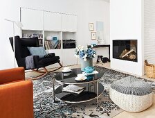 Living room with white cabinets and shelves, rocking chair, fireplace, side table and beanbag