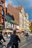 View of cyclists and cafes on street in Linden, Hannover, Germany