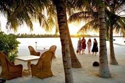 Tables laid on beach at dusk in Veligandu Island Resort, Maldives