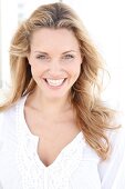 Portrait of happy woman wearing white tunic blouse, smiling