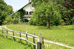 View of house with balcony and fence in garden