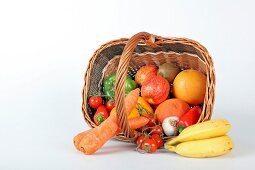 Basket of fruit and vegetables on white background