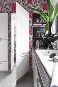 Kitchen pantry with ladder against patterned wallpaper