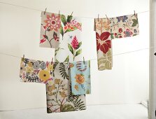 Variety of table cloth with floral print hanging on cloth line