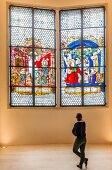 Woman standing in front of Kaiser window, Augustiner Museum, Freiburg, Germany