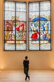 Woman standing in front of Kaiser window, Augustiner Museum, Freiburg, Germany