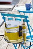 Striped linen bag hanging on blue chair
