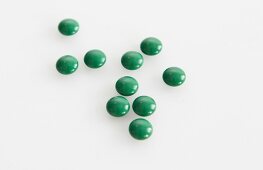Close-up of green pills on white background