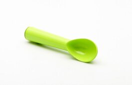 Green ice cream spoon on white background