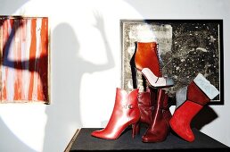Various red and patterned ankle length boots on table