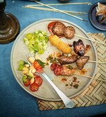 Roasted meat and vegetable skewers on plate