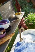 Glasses and crockery in a sink in a garden