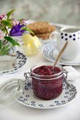 Boysenberry jam in a jar with crackers and butter