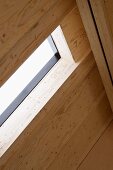 Detail of a wood paneled roof pitch and skylight window
