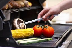 Vegetables and corn on the cob on a barbecue