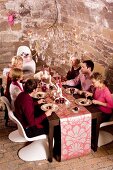 A party eating Christmas dinner in a vaulted cellar