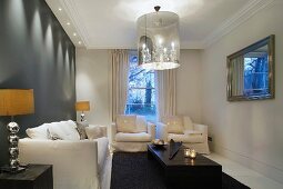 Eleganter Wohnraum mit Polstergarnitur und Designer Hängelampe mit integriertem Kerzenleuchter