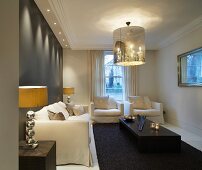 Elegant living room with upholstered sofas and chandelier with shade