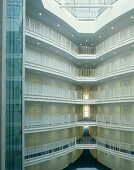 Open stairwell in a multi-story building with railings along the corridors