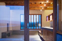 View through open sliding door into a kitchen with patio doors