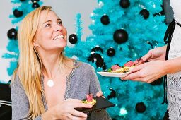 A woman eating a Christmas canapé