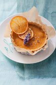 An orange tartlet with a sage flower