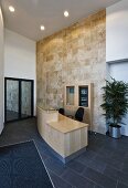 Modern reception hall with wooden counter on a gray slate floor